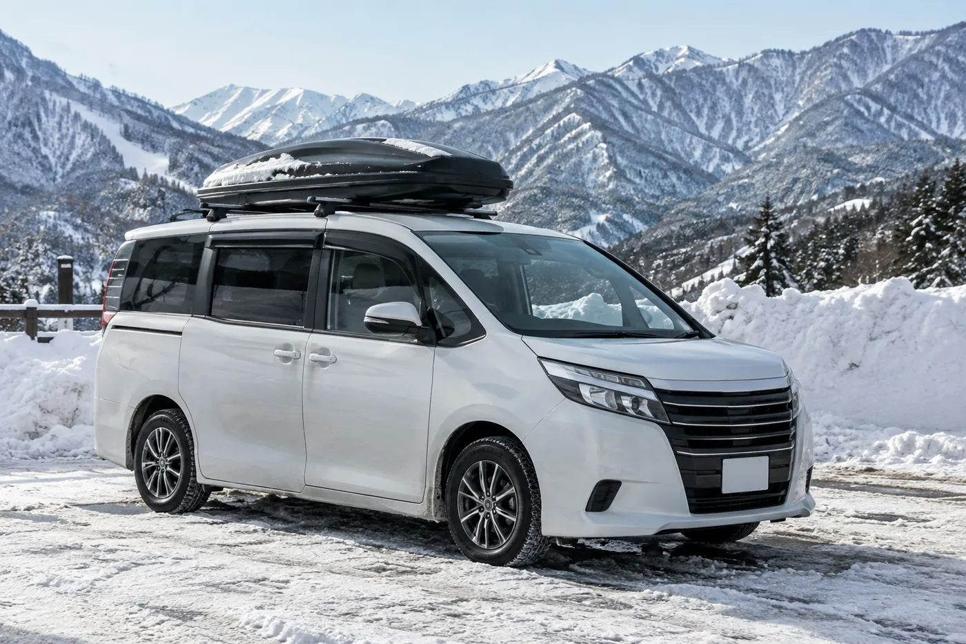 雪山の見える駐車場に、ルーフボックスを載せた大きなミニバンが止まっているイメージ(AI生成)